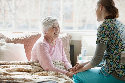 Elderly woman with caregiver at home.