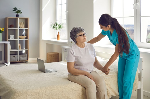 Healthcare worker assisting elderly woman at home.
