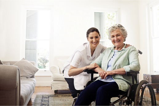 Caregiver smiling with woman in wheelchair.