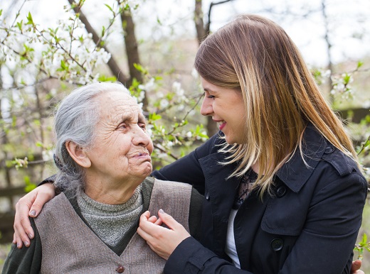 Elderly woman and younger woman smiling together.