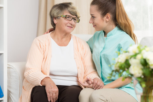 Elderly woman and caregiver sitting together.