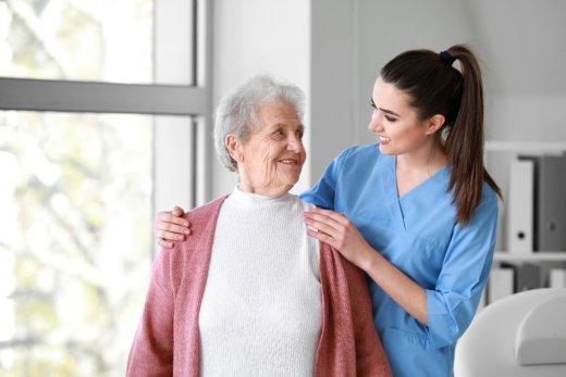 Nurse comforting elderly woman in bright room.